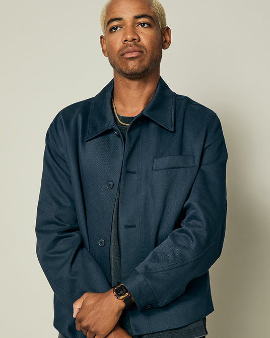 Man wearing a navy blue jacket against a plain background