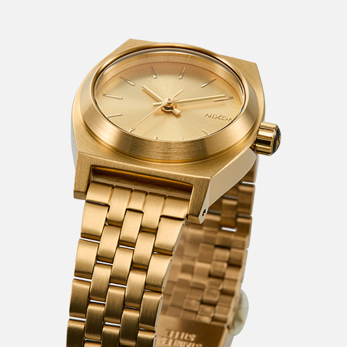 Gold Nixon watch with a white background