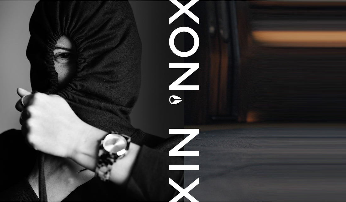 A person wearing a black hoodie with only one eye visible, wearing a watch, next to the word "XON.NIX" in white text.